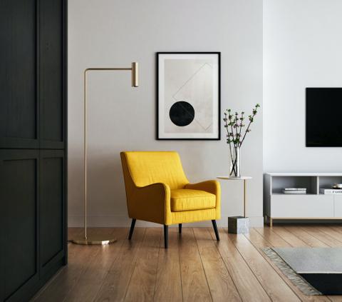 Modern living room interior with yellow accent chair, wall art, and wooden flooring by MAJISA Furniture.